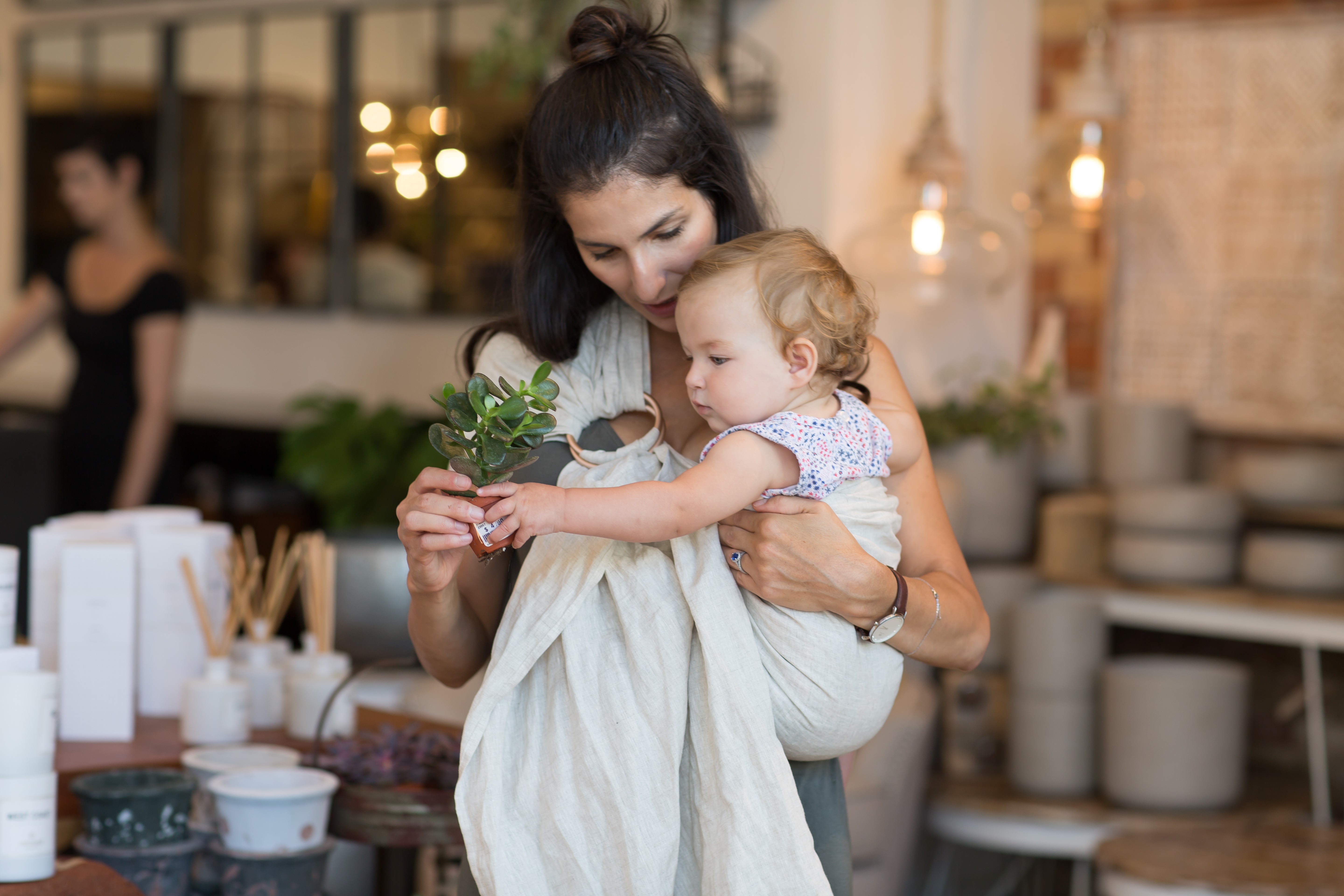 A mom wearing a sustainably made sling for her baby 